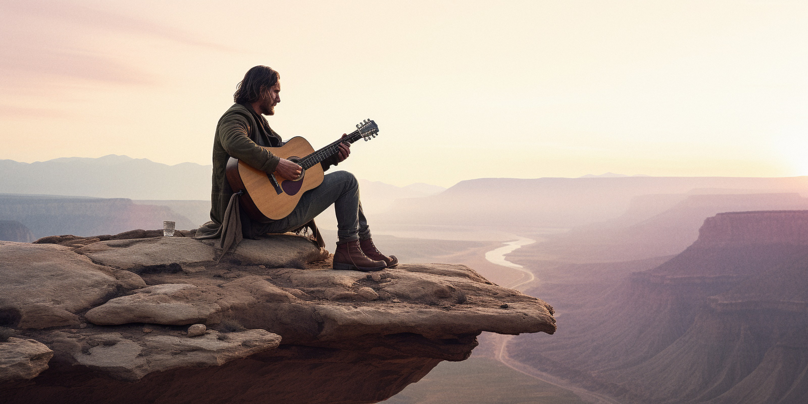 Gabby playing guitar above a vast canyon.